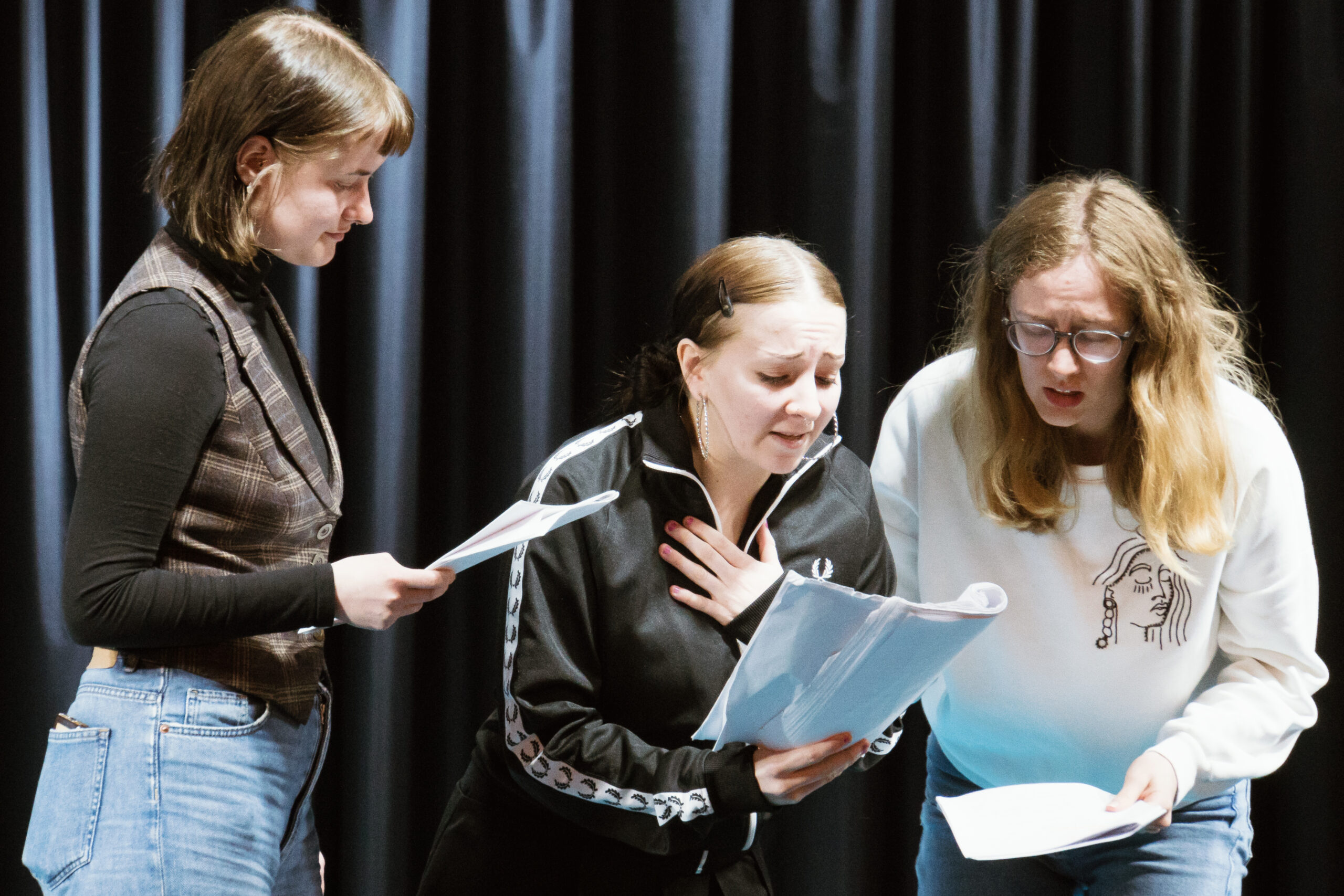 Das brennende Dorf - Probeneindrücke - drei Schauspielerinnen gemeinsam auf der Bühne; zwei Schauspielerinnen auf der rechten Bildseite mit theatralischem Gesichtsausdruck