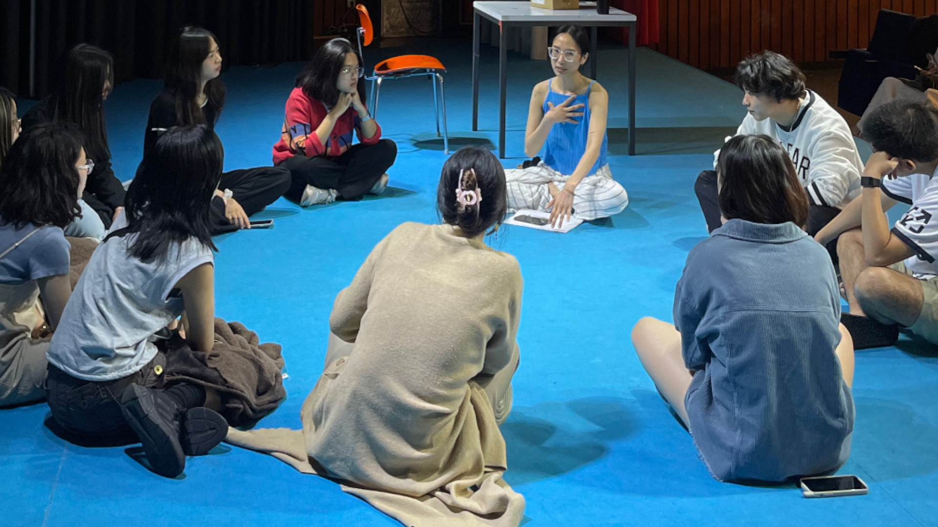 Hoi - Vietnamesischer Kulturabend - Die Teilnehmerinnen und Teilnehmer des Kulturabends sitzen gemeinsam im Kreis auf dem Fußboden.