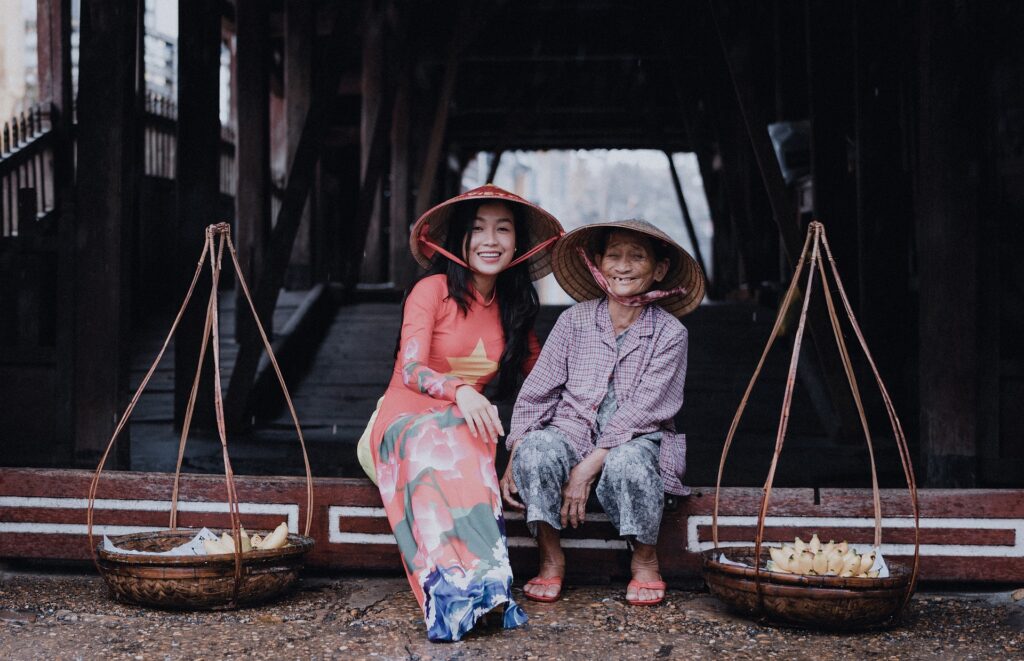 Zwei Generationen Vietnamesinnen zusammen in traditionellen Kleidung.